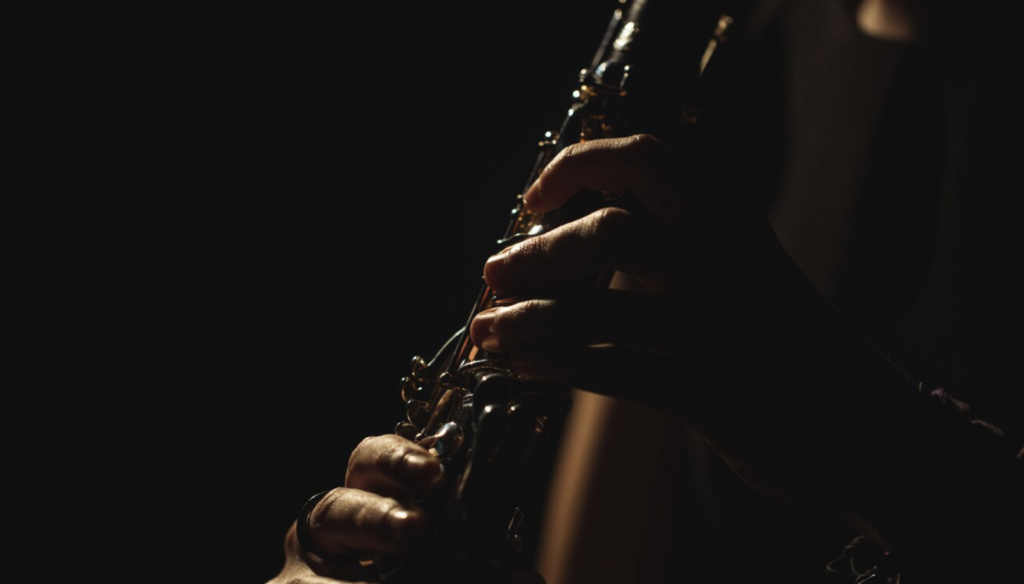 persona tocando una canción en saxofon